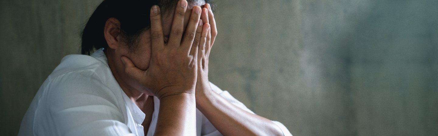 A woman covering her face with hands